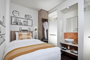 ein Schlafzimmer mit einem Bett und einem Waschbecken in der Unterkunft Hotel Clover The Arts in Singapur