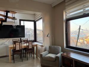 a living room with a table and chairs and a television at Heavenly Peace Stunning View Terrace Jacuzzi in Istanbul