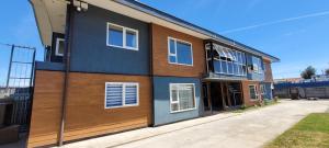 a house with a blue and wooden facade at Suites Oriente in Osorno