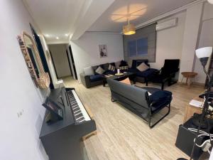 a living room with a piano and a couch at Les Nuits de Miel - Marrakech in Marrakech