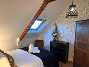 a bedroom with a bed with two towels on it at Les libellules, maison de ville, classé 4 étoiles avec baignoire spa à Dinan Lanvallay in Lanvallay