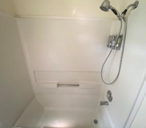 une douche avec pommeau de douche dans une salle de bain dans l'établissement River Access at Blanco River, Charming Big Cottage, à Wimberley