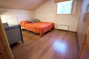 a bedroom with an orange bed in a room at Aurinko Saaga 3 in Ukkohalla