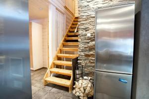 a kitchen with a staircase next to a refrigerator at Aurinko Saaga 3 in Ukkohalla