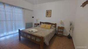 a bedroom with a bed with two yellow pillows at Punto Sur Departamentos in Tandil