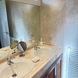 a bathroom with two sinks and a large mirror at Retiro verde en Madrid in Quintana +14 photos