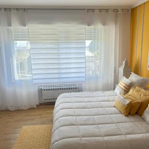 a bedroom with a large white bed and a window at Retiro verde en Madrid in Quintana
