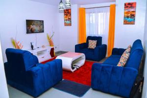 a living room with two blue chairs and a red rug at GCurtway Homes Nyayo 3 bedroom in Nairobi