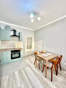 a kitchen with a table and chairs in a room at Аэропорт апартамент in Almaty