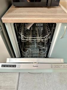 a dishwasher with some dishes inside of it at Аэропорт апартамент in Almaty +1 photo
