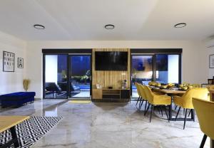 een woonkamer met een tafel en gele stoelen bij Villa Good Vibes with heated pool in Kod Mula