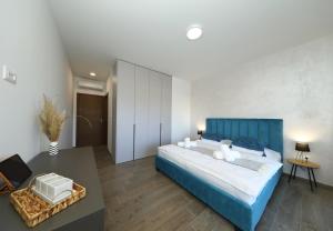 een grote slaapkamer met een blauw bed en een tafel bij Villa Good Vibes with heated pool in Kod Mula +26 foto's