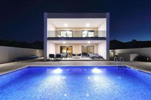 een zwembad voor een huis 's nachts bij Villa Good Vibes with heated pool in Kod Mula