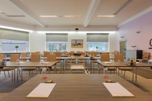 フランクフルト・アム・マインにあるTagungshotel Höchster Hofの部屋にテーブルと椅子が置かれた教室