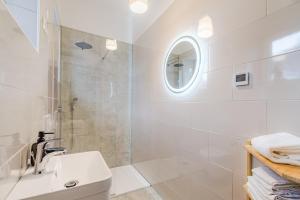 a white bathroom with a sink and a shower at Apartment Vandora in Idrija