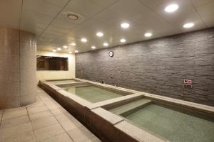 a swimming pool in a building with a brick wall at Geoje Samsung Hotel in Geoje
