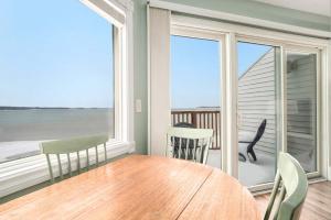 a dining room with a table and a view of the ocean at Beachside 325 Waterfront Condo in Traverse City