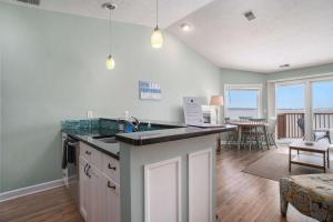 a kitchen with a counter and a dining room at Beachside 325 Waterfront Condo in Traverse City +19 photos
