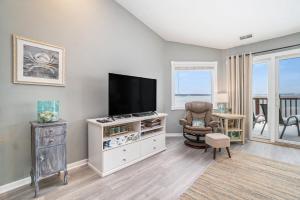 a living room with a flat screen tv and a chair at Beachside 323 Waterfront Condo in Traverse City