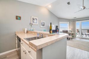 a kitchen with a sink and a living room at Beachside 323 Waterfront Condo in Traverse City +22 photos