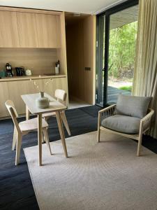 a living room with a table and a chair at Capsula aan de Wadi in Diepenheim