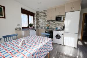 a kitchen with a table and a refrigerator and a washing machine at Casa Melina in Villapedre +8 photos