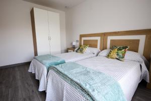 two beds sitting next to each other in a room at Casa Melina in Villapedre