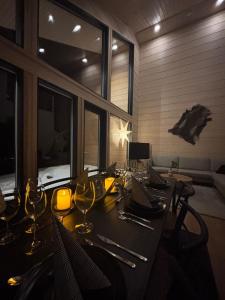 Un comedor con una mesa con copas de vino. en Villa Chill Levi, en Kittilä
