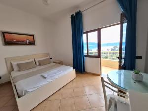 a bedroom with a bed and a glass table at Hotel Sirena in Vlorë