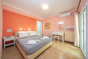 a bedroom with a bed and a bathroom with a sink at Stella Hotel Apartments in Fiskardo