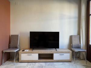 a living room with a television and two chairs at La Corrala de Chite in Lecrin