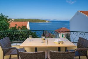 a table with two glasses of wine on a balcony at Stella Hotel Apartments in Fiskardo