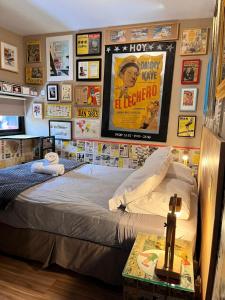 a bedroom with a bed with a poster on the wall at La Nueva Posadita in Colonia del Sacramento