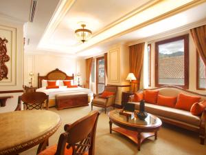 a hotel room with a bed and a couch and a table at Plaza Grande Hotel in Quito