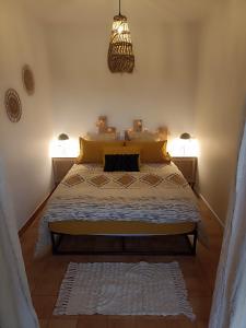 a bedroom with a bed with yellow pillows at La petite maison à la campagne ! in Parcé-sur-Sarthe