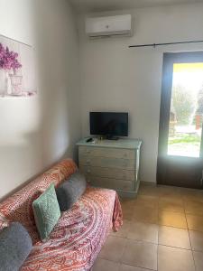 a bedroom with a bed and a dresser with a television at Villette Oasi in San Teodoro