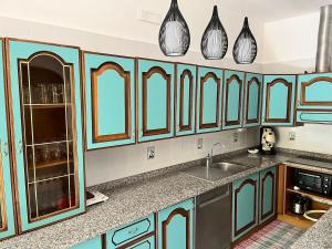 a kitchen with blue cabinets and a sink at Villa Annette #Vivere la Puglia in Villa Castelli