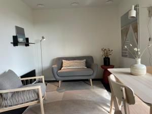 a living room with a couch and a chair at Capsula aan de Wadi in Diepenheim