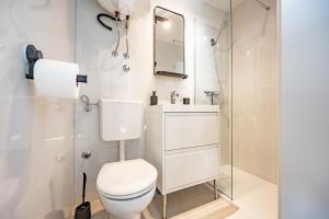 a white bathroom with a toilet and a mirror at Apartments Kržanić in Podgora +67 photos