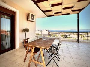 una sala da pranzo con tavolo e sedie su un balcone di Sunrise Studio with unhindered view to the sea. a Nea Makri