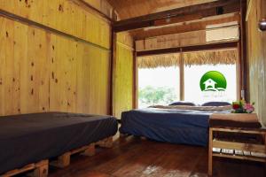 two beds in a room with a window at Ba Be Retreat in Bak Kan