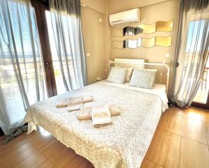 una camera da letto con un letto con asciugamani sopra di Sunrise Studio with unhindered view to the sea. a Nea Makri