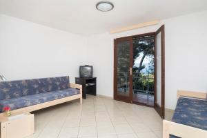 a living room with a couch and a tv at Apartments Kanegra Plava Laguna in Umag