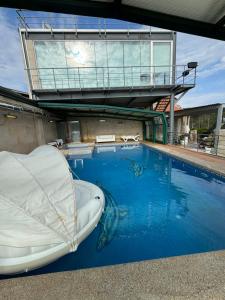 a swimming pool with a boat in the water at Apartamento Cubo de Cristal con piscina y vistas al mar in O Grove +17 photos