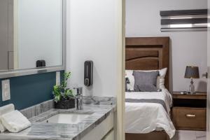 a bedroom with a bed and a sink and a mirror at Refugio exclusivo en Zapotlanejo centro Suite 303 in Zapotlanejo