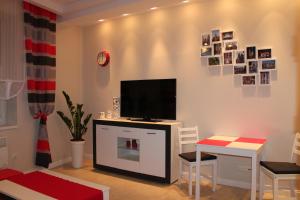sala de estar con TV, mesa y sillas en Carmen Apartment, en Cracovia