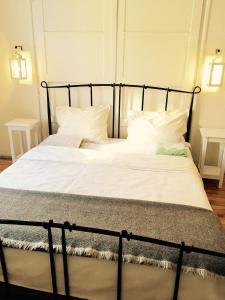 een bed met een zwart frame en witte kussens bij Interhost Guest rooms and apartments in Sofia