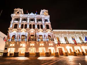 a large white building at night with lights at Plaza Grande Hotel in Quito