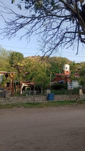 una casa con una recinzione in pietra e un edificio con un silo di Willca Pirul a San Marcos Sierra