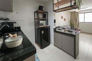 a kitchen with black counter tops and a counter top at Flat Super Aconchegante Intermares 4 Pessoas in Cabedelo